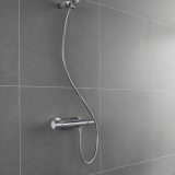 Lifestyle image of the Roca Flex Chrome 1500mm Anti-Twist Shower Hose connected to a shower head and outlet